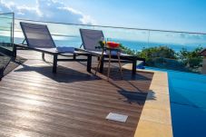 Swimming pool with sun loungers and sea view